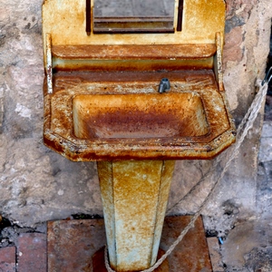 Lavabo ancien en métal rouillé accroché à un mur au moyen d'une corde - France  - collection de photos clin d'oeil, catégorie clindoeil